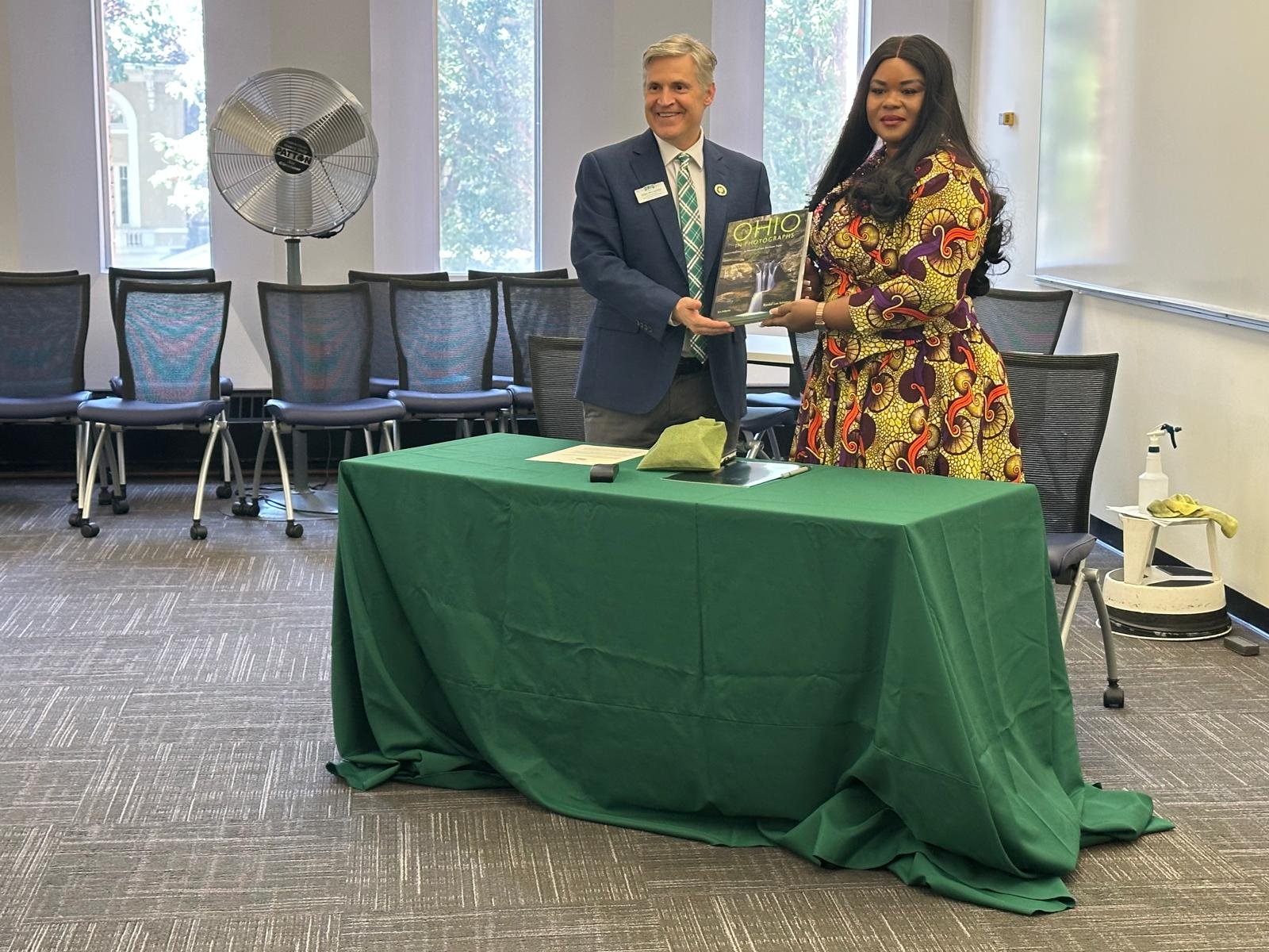 Dr. John McCarthy presenting a book on Ohio to Ruth Dela Seddoh