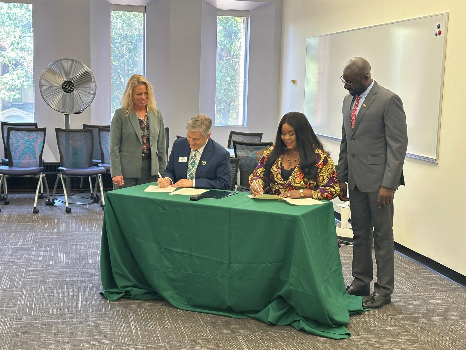 Ruth Dela Seddoh and Dr. John McCarthy signing the MOU in Athens, Ohio, with BAE and university representatives looking on